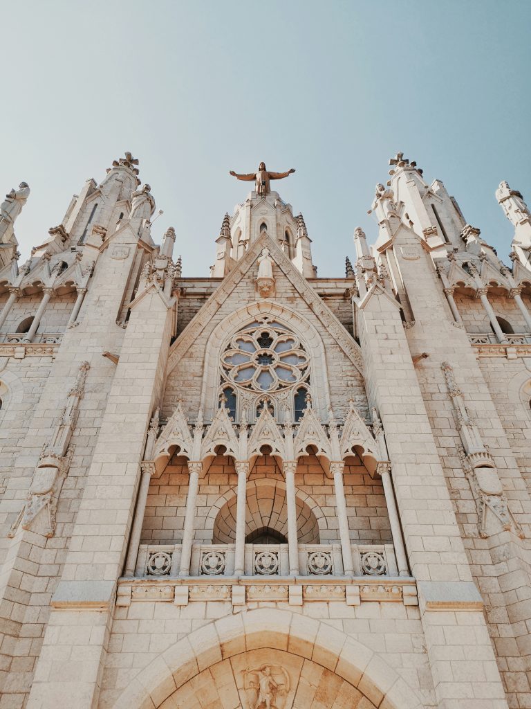 Ornate stone church facade with towers and a rose window